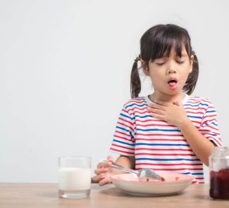 Mädchen hat Beschwerden beim Essen – das Kind leidet unter Reflux und Sodbrennen.