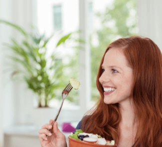 Richtige Ernährung bei Sodbrennen: Junge Frau isst einen Salat.
